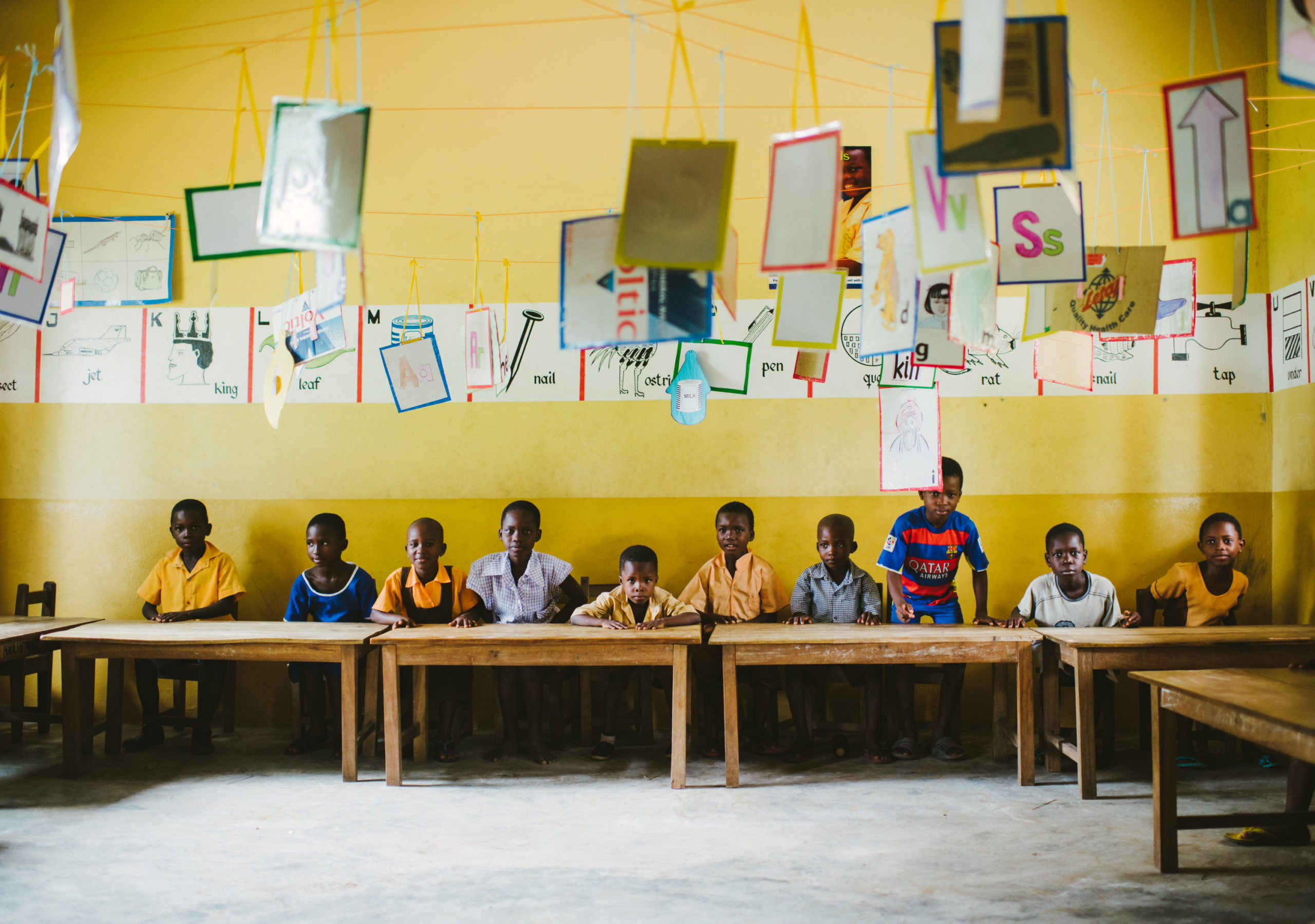 A group of students in Ghana sit at their desks inside the classroom.