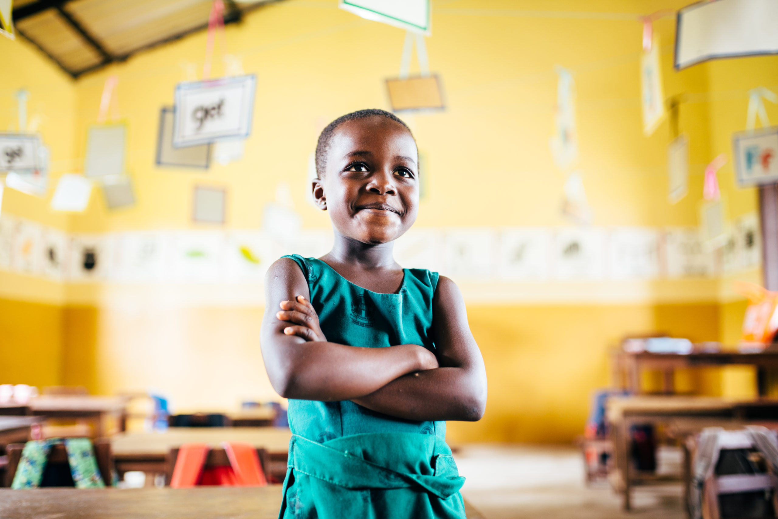 A student in Ghana stand at their desk in a PoP supported classroom | Photo credit: Timmy Shivers