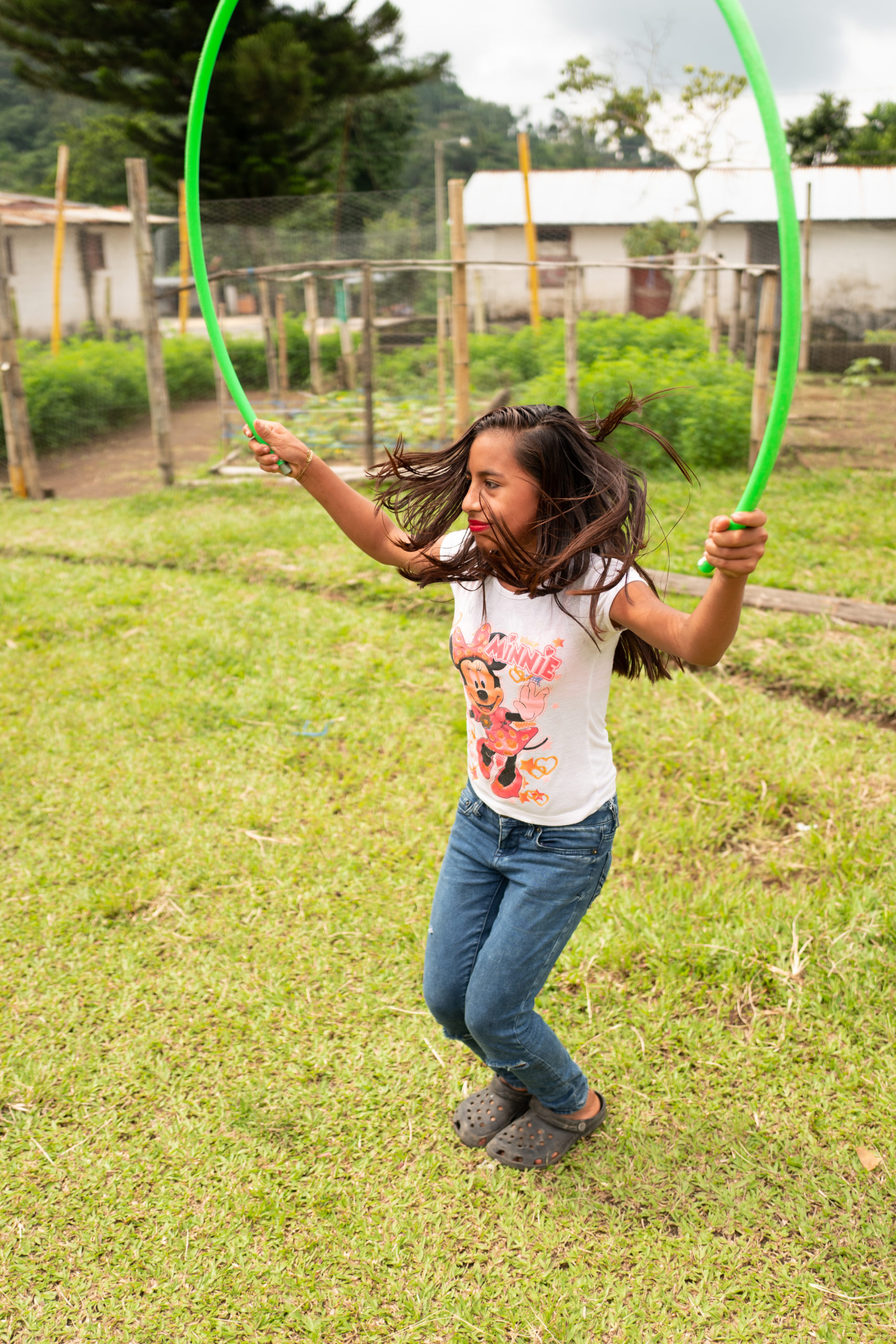 A student in Guatemala plays with a jump rope on school grounds